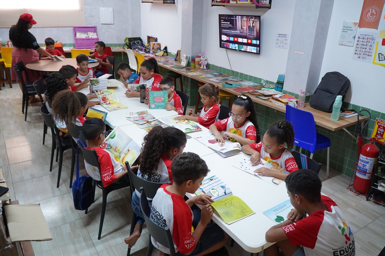 why-choose-us Children engaged in reading at a community library in Glória do Goitá, Brazil.