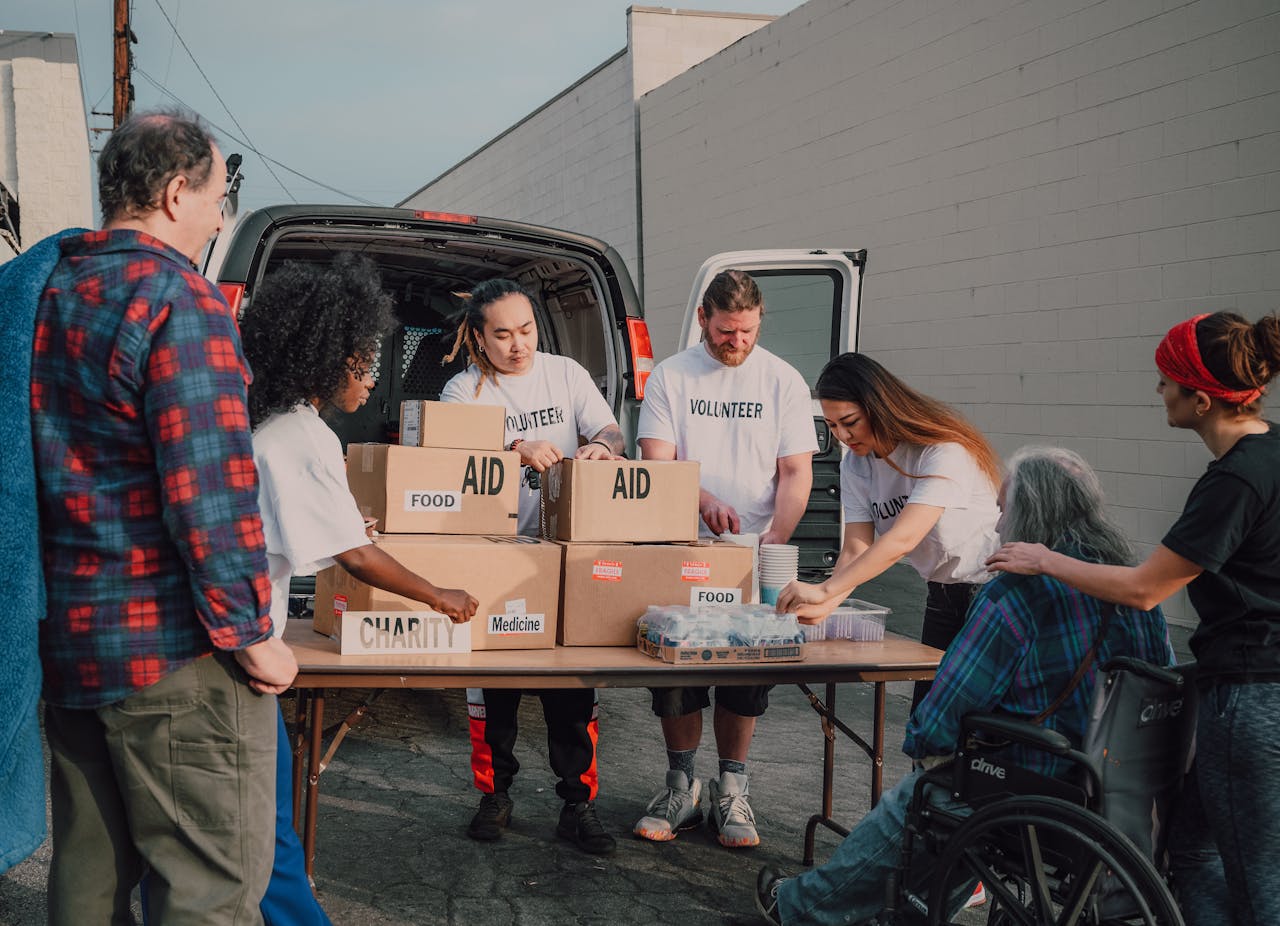 about-01 Group of diverse volunteers organizing aid packages outdoors for a charity event.